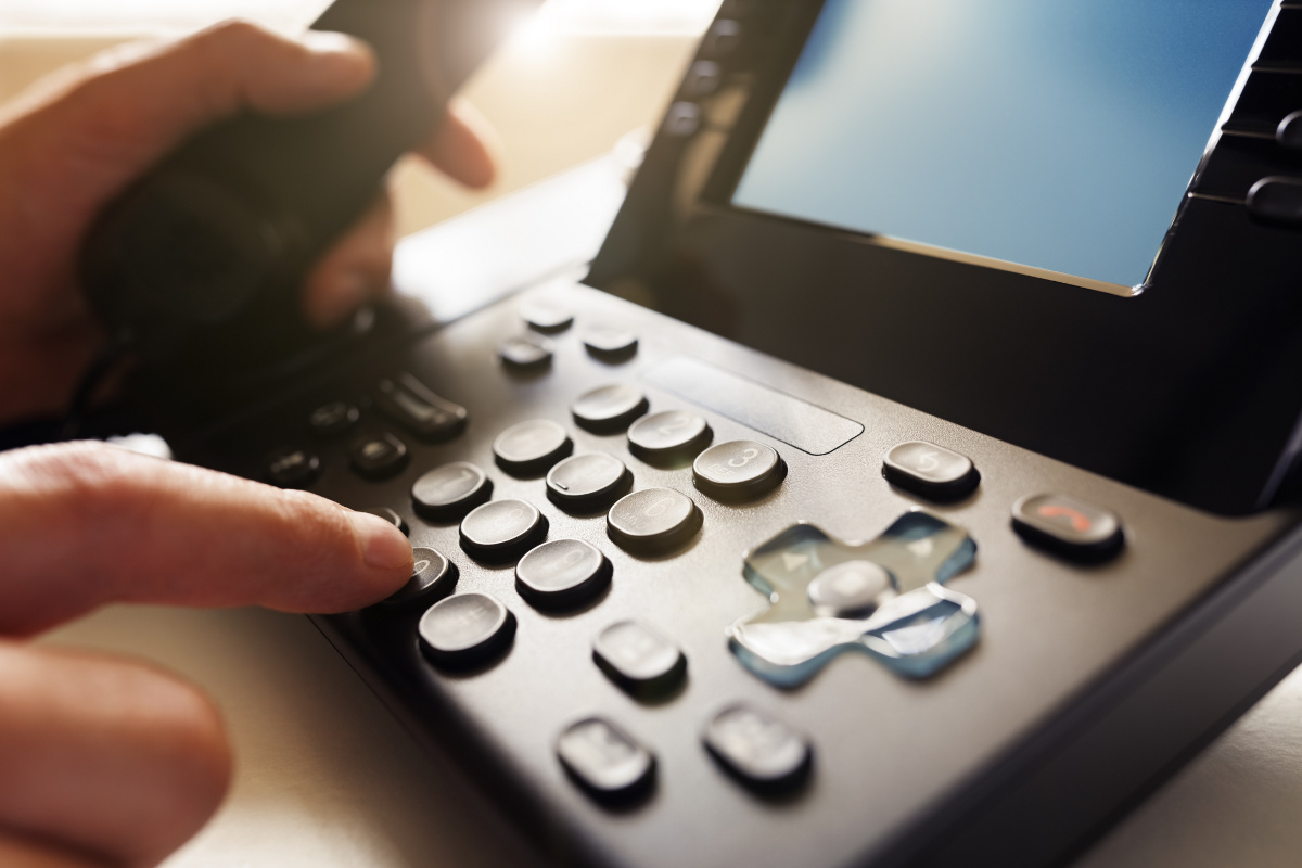 Close Up of Hand Dialing VoIP Phone