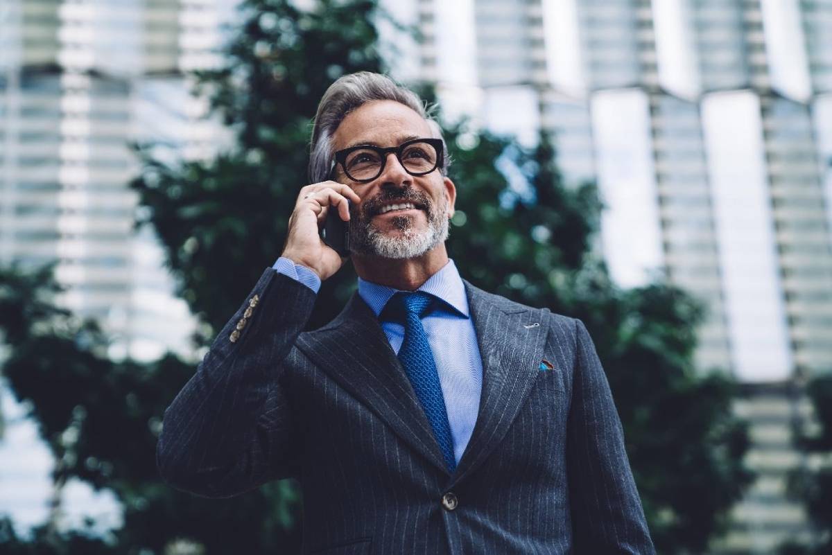 A man in a pinstripe suit talking on the phone.