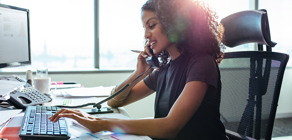 Businesswoman at Desk on Phone and Computer